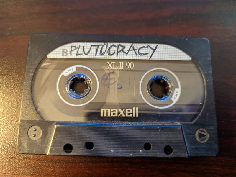 Plutocracy Live – Early Early Pluto With Jessie Simmers On Vocals – Cassette Tape